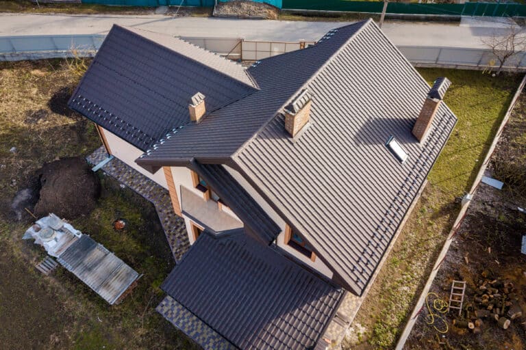 Aerial top view of building steep shingle roof, brick chimneys a